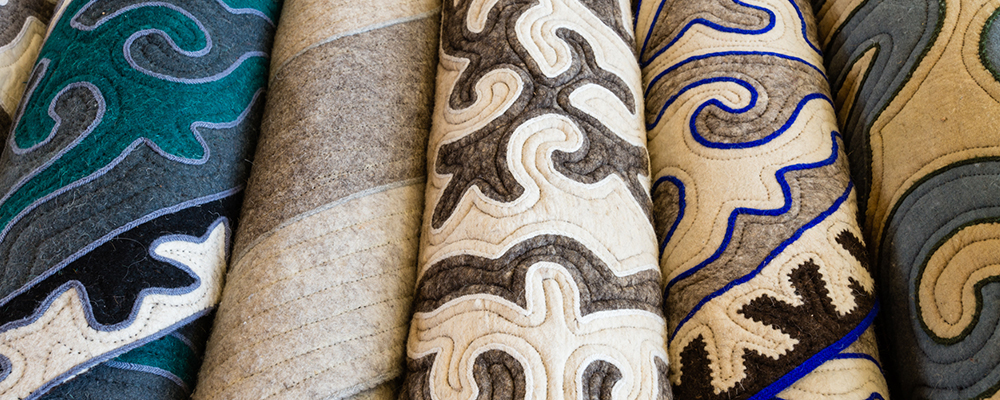 Assortment of shyrdak rugs on display image